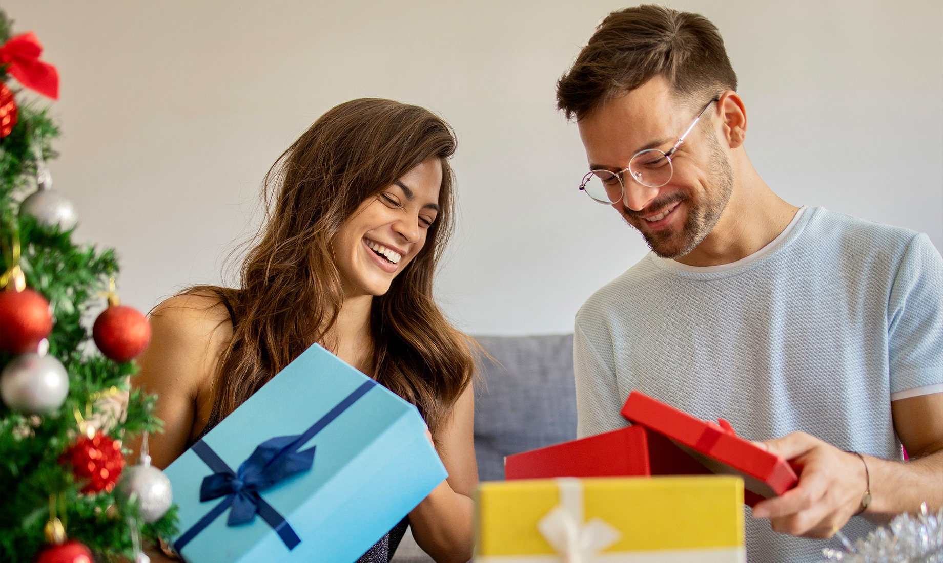 A couple opening Christmas presents.