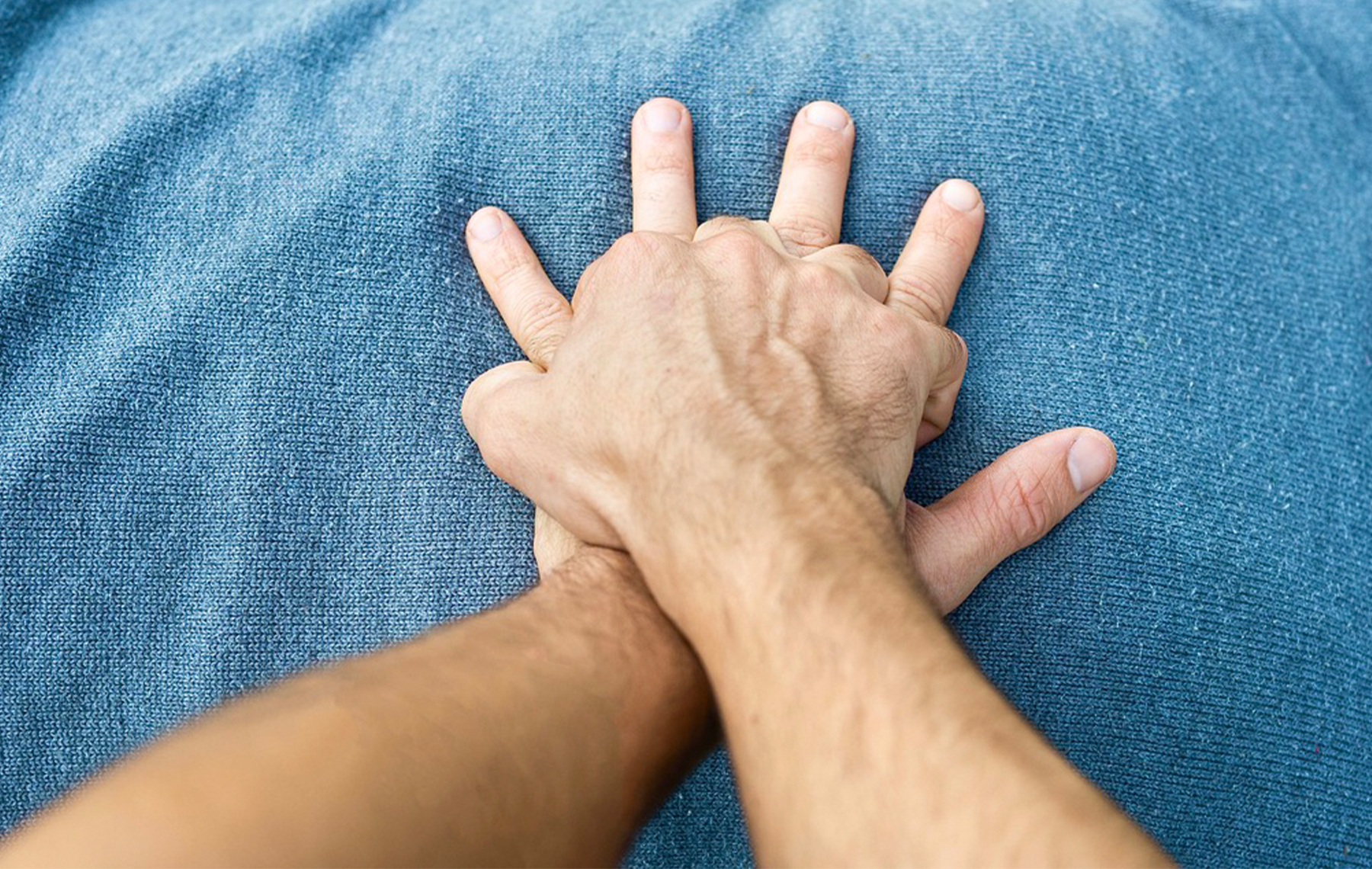 A closeup of hands performing CPR on a chest.