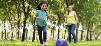 A child plays with her mom outside.