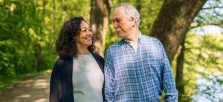 A happy senior couple walks in the park.