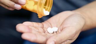 Closeup of a man's hand holding opioids.