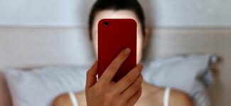 A woman reads the news on her smartphone.