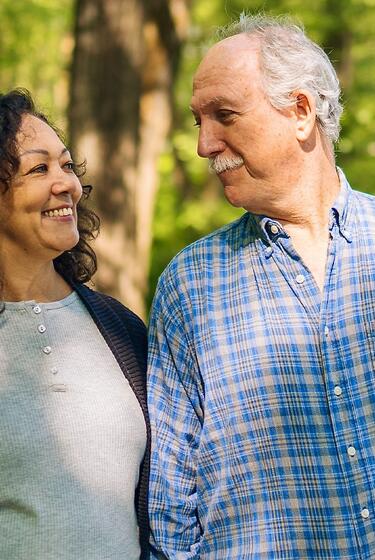A happy senior couple walks in the park.