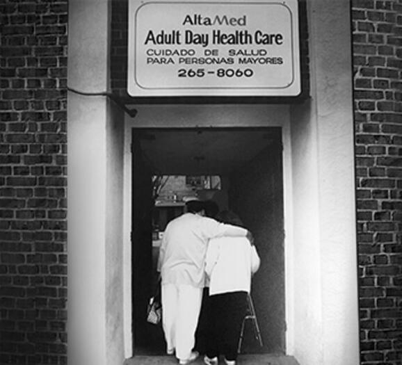 Doctor and a patient passing through the entrance of Adult Day Health Care center